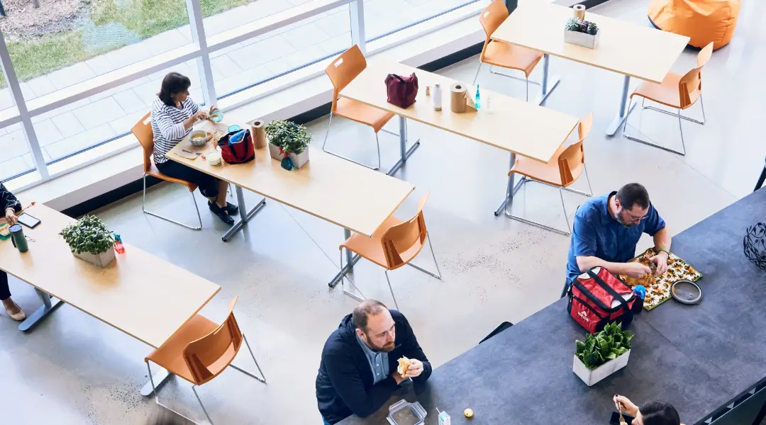 Employees seated in a bright, modern cafeteria space at ISAAC Instruments