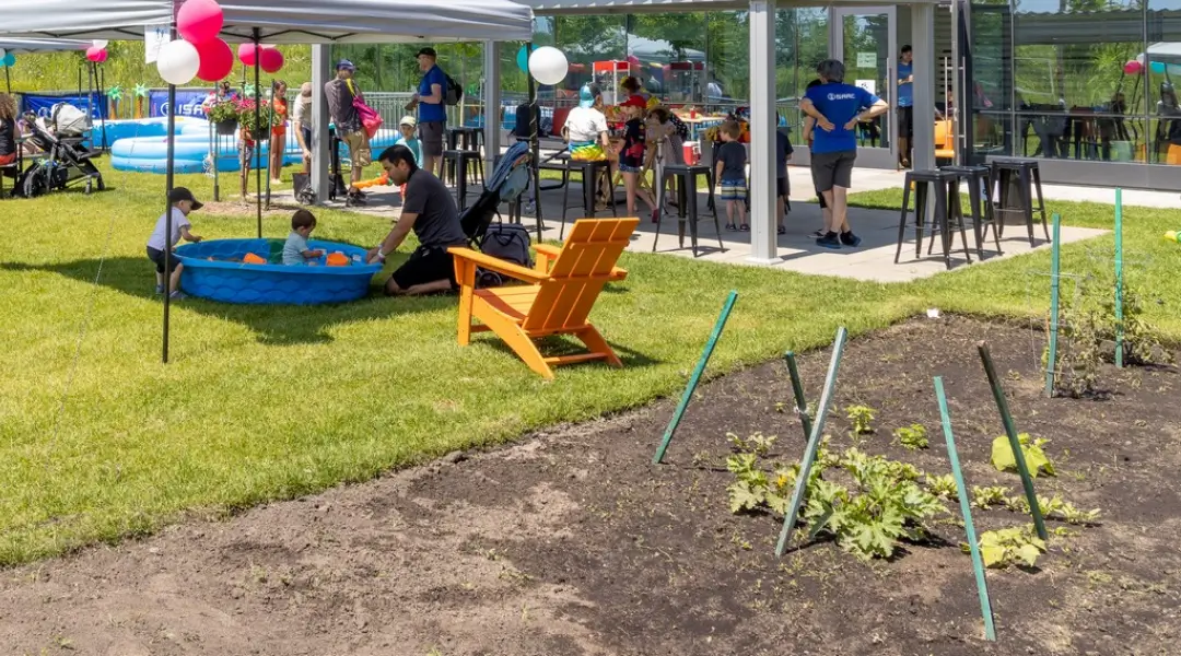 Parents and children enjoying outdoor games and a small pool at an ISAAC Instruments company event